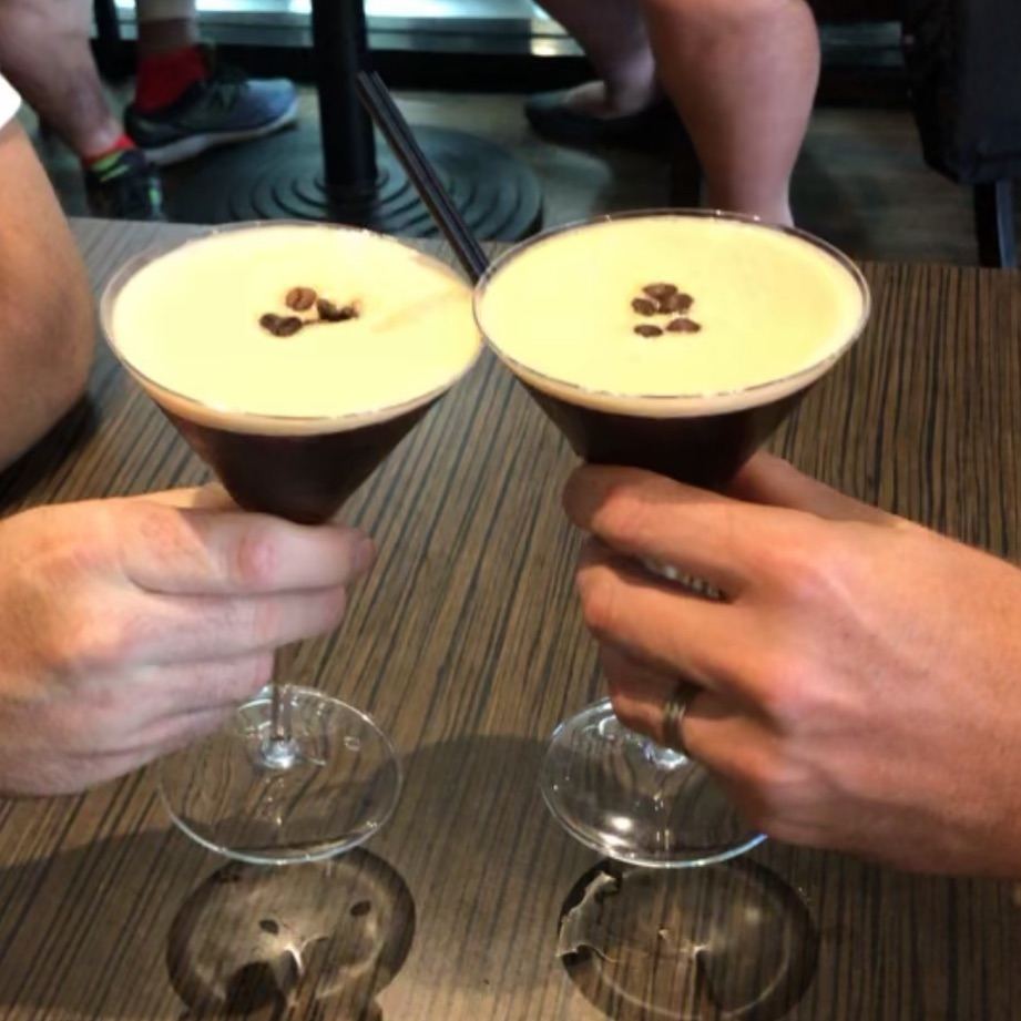 Two espresso martinis raised in a toast